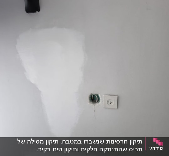 קיר עם תיקוני צבע ושקע חשמל